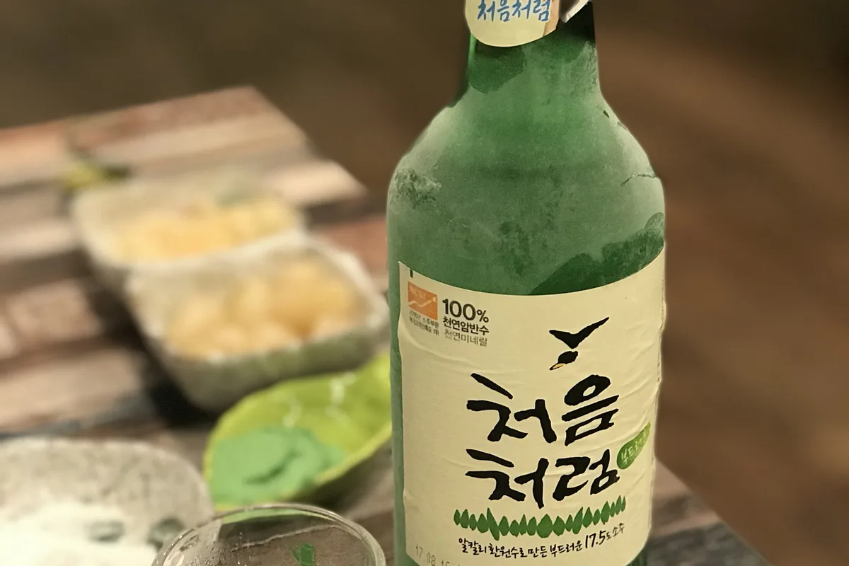 A bottle of soju on a restaurant table — the company drinking session, or 회식, is one of gapjil's most common everyday vehicles